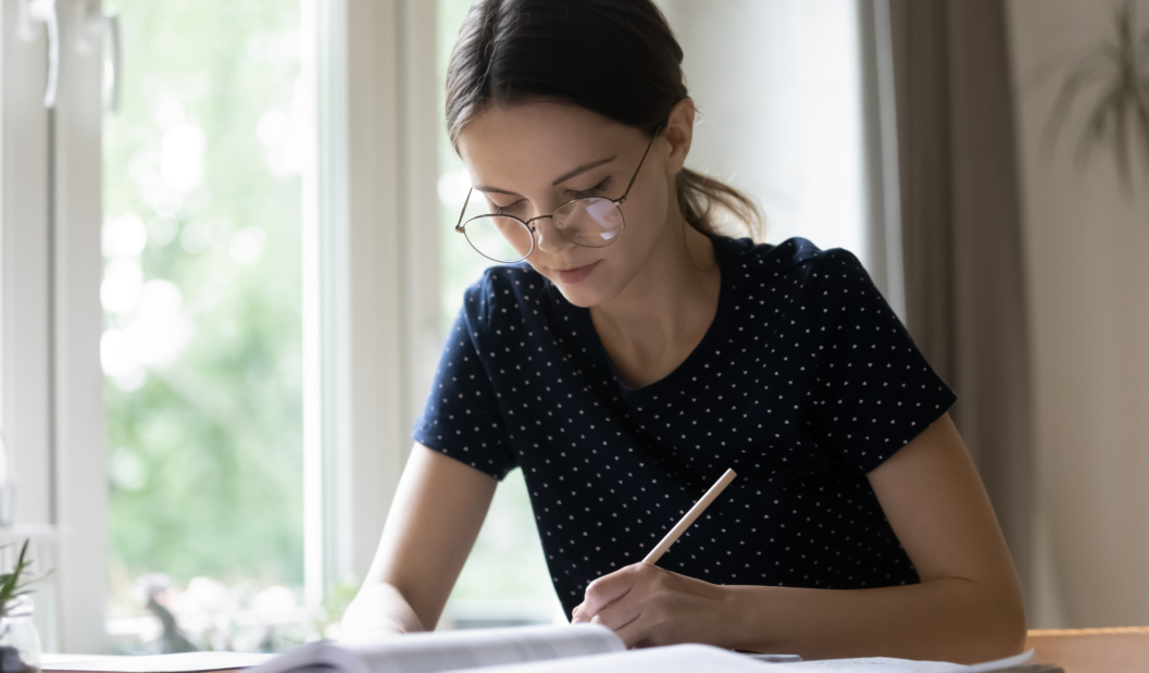 High School Student Sitting At Table Learns Language